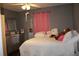 Cozy bedroom featuring grey walls, a full bed, and natural light from a nearby window at 1302 Buttercup Ct, Lawrenceville, GA 30044