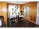 Cozy dining room featuring wooden floors, wood paneled walls, and double doors to an outdoor area at 1302 Buttercup Ct, Lawrenceville, GA 30044