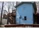 Charming blue home with a wood staircase and quaint front door nestled in a wooded setting at 1302 Buttercup Ct, Lawrenceville, GA 30044