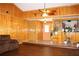 Open living room with wood paneling, a ceiling fan, and hardwood floors at 1302 Buttercup Ct, Lawrenceville, GA 30044