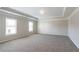 A large bedroom featuring tray ceiling detail, recessed lighting, carpet flooring, and natural light at 7416 Toccoa Cir, Union City, GA 30291