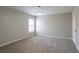 This bedroom is carpeted with a window providing light, and neutral colored walls at 7416 Toccoa Cir, Union City, GA 30291
