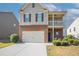 Charming two-story home with a brick and shingle exterior featuring a two-car garage and inviting front porch at 7416 Toccoa Cir, Union City, GA 30291