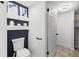 A modern half bathroom with a toilet, artwork, and shelving, provides a stylish and convenient space for guests at 199 14Th Ne St # 2312, Atlanta, GA 30309