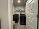 Compact laundry room with black washer and dryer and overhead shelf at 338 Cherryhill Ln, Woodstock, GA 30188