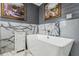 Bathroom with a sleek white soaking tub and marble accent wall and floor at 8 Colonial Club Se Dr, Acworth, GA 30102