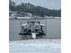 A covered boat dock with a staircase and deck, offering stunning views of the snow-covered lake and shore at 8 Colonial Club Se Dr, Acworth, GA 30102