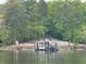 Waterfront view of a boat dock with boat slip and upper deck for outdoor activities at 8 Colonial Club Se Dr, Acworth, GA 30102