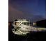 Nighttime view of a boat dock with ramp and stairs, beautifully lit against the dark water and sky at 8 Colonial Club Se Dr, Acworth, GA 30102