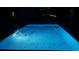 A vibrant blue swimming pool with a ladder, lit up at night at 8 Colonial Club Se Dr, Acworth, GA 30102