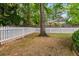 A tree-lined backyard featuring a white picket fence and lush greenery, providing a private outdoor space at 2149 Whittier Nw Pl, Atlanta, GA 30318