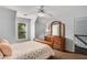 Cozy bedroom with a ceiling fan and a wooden dresser with decorative mirror, complemented by a window view at 2149 Whittier Nw Pl, Atlanta, GA 30318