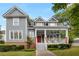 Charming two-story home featuring a inviting front porch and gray siding, surrounded by mature trees and landscaping at 2149 Whittier Nw Pl, Atlanta, GA 30318