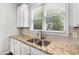 Kitchen sink and counter area, featuring granite countertops, a stainless steel sink, and white cabinetry at 2149 Whittier Nw Pl, Atlanta, GA 30318