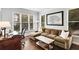 Comfortable home office with a brown sofa, desk, and plenty of natural light from the large windows at 2149 Whittier Nw Pl, Atlanta, GA 30318