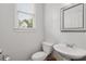 Clean powder room with a pedestal sink, toilet, and classic mirror at 2149 Whittier Nw Pl, Atlanta, GA 30318