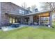Backyard features an outdoor kitchen and living area on a stone patio and grass at 3338 Breton Ne Cir, Brookhaven, GA 30319