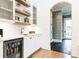 Elegant bar area with floating shelves, stylish decor, and a beverage fridge at 3338 Breton Ne Cir, Brookhaven, GA 30319