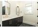 Modern bathroom featuring double vanity, black cabinets, gold fixtures, and herringbone tile floor at 3338 Breton Ne Cir, Brookhaven, GA 30319