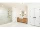 Bright bathroom with a glass shower, wooden vanity, marble countertop, and modern fixtures at 3338 Breton Ne Cir, Brookhaven, GA 30319