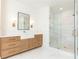 Bathroom with wood vanity, marble countertop, framed mirror, sleek fixtures, and glass-enclosed shower at 3338 Breton Ne Cir, Brookhaven, GA 30319