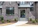 Inviting front entrance featuring a brick facade, black framed windows, and stone steps with manicured landscaping at 3338 Breton Ne Cir, Brookhaven, GA 30319