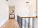 Hallway featuring hardwood floors, white walls, black railings, and modern light fixture at 3338 Breton Ne Cir, Brookhaven, GA 30319