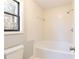 Bathroom with white tiled shower over tub and single window providing natural light at 3485 Sheree Trl, Stone Mountain, GA 30087