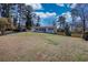 Expansive front yard leading to a charming home with lush greenery and a fenced perimeter at 6751 Davidson Ct, Lithonia, GA 30058