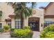 Exterior of building entrance featuring double doors, landscaping with a palm tree, and well-maintained greenery at 955 Juniper Ne St # 4125, Atlanta, GA 30309