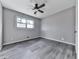 Bedroom features hardwood flooring, neutral walls, baseboard trim, and natural light from the window at 1036 Pinetree Ct, Powder Springs, GA 30127