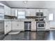 Bright kitchen with stainless steel appliances, white cabinets, and sleek black flooring at 1036 Pinetree Ct, Powder Springs, GA 30127