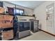 Laundry room with modern washer, dryer, overhead shelving, and neutral walls at 1036 Pinetree Ct, Powder Springs, GA 30127