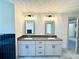 Modern bathroom with dual sinks, gray cabinetry, and elegant mirrors offers a sleek design at 254 Lotus Ln, Covington, GA 30016