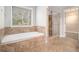 Bathroom featuring a bathtub and a glass-enclosed shower with tan tiling at 2725 Palmview Sw Ct, Atlanta, GA 30331