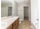 Bright bathroom featuring double sinks with wooden cabinets and a separate toilet area at 3127 Leyland Ct, Decatur, GA 30034