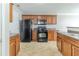 Functional kitchen with wood cabinetry, black appliances, and laminate countertops at 3127 Leyland Ct, Decatur, GA 30034