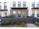 Inviting townhome featuring a brick facade, dark trim, covered entry, and tidy front yard with wood fence at 852 Constellation Dr, Decatur, GA 30033