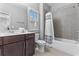 Well-lit bathroom featuring modern fixtures, a tiled shower-tub, and a dark wood vanity at 207 Cole Ne St, Marietta, GA 30060