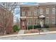 Attractive brick townhomes featuring well-manicured landscaping, complemented by inviting entrances and a sidewalk at 207 Cole Ne St, Marietta, GA 30060