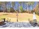 Landscaped backyard with stone patio featuring outdoor seating and views of trees at 3198 Highland Forge Trl, Dacula, GA 30019