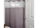 Bathroom with a patterned shower curtain, white vanity, and door that is partially open at 3198 Highland Forge Trl, Dacula, GA 30019