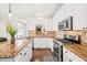 This renovated kitchen features granite countertops, stainless steel appliances and white cabinets at 3198 Highland Forge Trl, Dacula, GA 30019