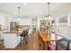 Open-concept kitchen and dining area with hardwood floors, white cabinets, and natural light at 3198 Highland Forge Trl, Dacula, GA 30019