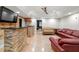 Well-lit living room featuring a stone bar, comfortable seating and tile flooring at 3198 Highland Forge Trl, Dacula, GA 30019