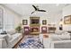 Inviting living room featuring a stone fireplace, ceiling fan, and comfortable furnishings at 3198 Highland Forge Trl, Dacula, GA 30019