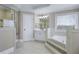 Bright bathroom with a tub, a tiled floor, white cabinets and walls at 3433 Pinemont Dr, Douglasville, GA 30135