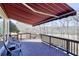 Inviting outdoor deck with wooden furniture and views of the trees and outdoor space, covered by a red and white awning at 3433 Pinemont Dr, Douglasville, GA 30135