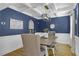 Formal dining room with wood floors, wainscoting, a wood table, and blue walls with decorative molding at 3433 Pinemont Dr, Douglasville, GA 30135