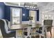 This elegant dining room features hardwood floors, a modern light fixture, and a dark blue accent wall at 3433 Pinemont Dr, Douglasville, GA 30135